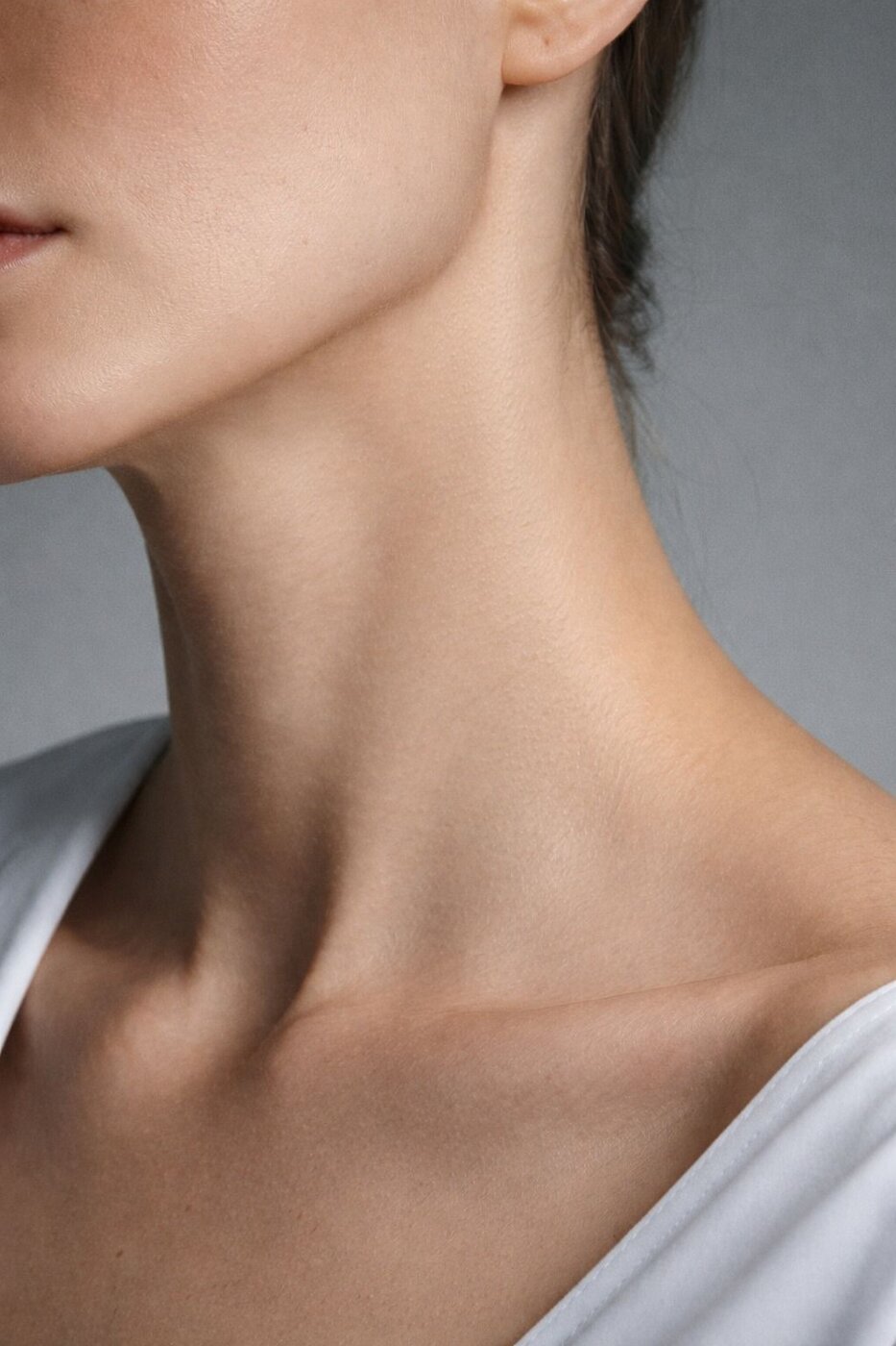 Close-up of a woman's defined jawline and neck, skin smooth with no puffiness