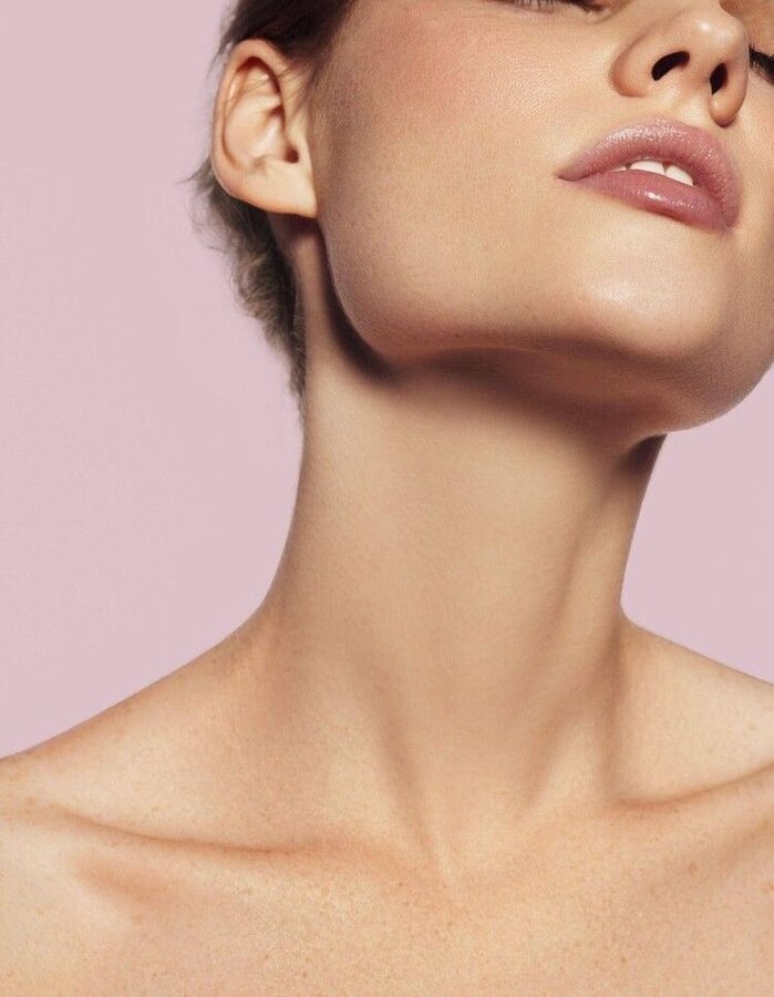 Close-up of a woman's collarbone and neck, sharp and de-puffed